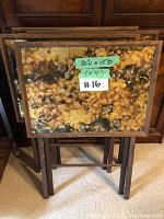 Four tray tables stacked together showing top surfaces and frames