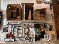 Assorted jewelry in individual boxes spread across a surface