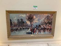 Full view of framed painting showing Paris riverbank scene with stone arch bridge and crowd