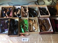 12 pairs of women's shoes in their original boxes and displayed on a carpeted floor.