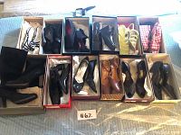 Top-down view of 12 pairs of women's shoes in original boxes arranged in two rows showing various styles and colors.