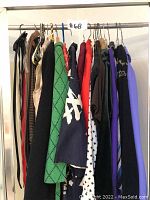 Clothing on hangers showcasing assorted colors and styles including belts and light outerwear