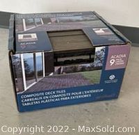 Photo of unopened box of composite deck tiles, showing packaging and branding details.