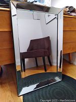 Full front view of the rectangular mirror showing reflective beveled glass frame and clear mirror surface.