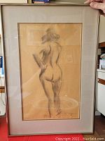 Photo of framed nude drawing signed by Tutzl Haspel Sequin, possibly charcoal or Conte crayon on manila paper, showing the full artwork under glass with reflection.