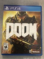 Front cover of PS4 Doom video game case showing armored character and game title, includes Mature 17+ rating and Demon Multiplayer Pack mention.