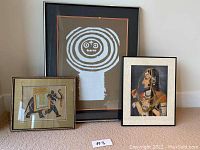 Three framed art pieces displayed: one large abstract print and two smaller Indian style paintings