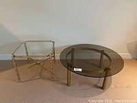 Two coffee tables side by side: one with a round smoked glass top and cylindrical gold legs, the other with an octagonal clear glass top and gold bamboo style metal legs.