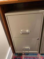 Gray two-door metal filing cabinet with two horizontal handles and bottom door lock, no key.