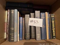 Top view of box with 14 various Jewish books, including several prayer books and historical texts.