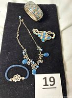 Four-piece jewelry set displayed on black background including Silpada necklace with blue beads, Brighton Eternal Sky cuff, Brighton Nadia bracelet, and Brighton Color Clique chord bracelet