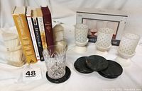 Photo showing all included items: books, onyx bookends, green marble coasters, cut glass tumbler, and candle set.