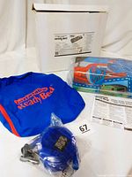 Photo showing the box with label, blue zippered carrying case with 'Inflatable Ready Bed' logo, foot pump in plastic, and an instruction sheet.