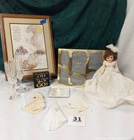 Full lot showing framed art, bridal doll, handkerchiefs, wooden sign, ceramic dish, and crystal glasses