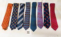All eight men's silk ties laid flat, showing front patterns and colors.