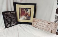 Lot of three framed and canvas wall decor pieces including a large framed art print of a woman, a rectangular serenity prayer canvas, and a motivational quote canvas.