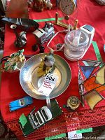 Photo showing copper and tin boat, metal train piggy bank, pencil sharpener, toy cars, small clock, and stained glass boat decoration