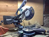 Rona 10 inch compound mitre saw showing overall body, base, and handle.