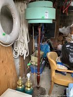 Full view of vintage wood base floor lamp with three tier green shade in need of repair, alongside two ceramic and metal table lamps with teal blue bodies and brass/gold accents.