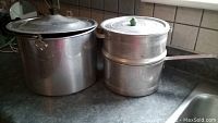 Aluminum pots: large pot with lid and steamer pot set on countertop