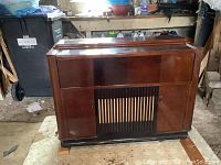 Front closed view of the polished wood cabinet stereo showing top sliding panel and front vents