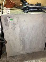 Photo of the square wood table top showing surface wear and scratches