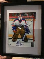 Framed 8x10 photo of NHL goalie Grant Fuhr in Edmonton Oilers uniform, signed and inscribed with "31" and "HHOF 03". Includes NHL hologram sticker and Frameworth authenticity sticker.
