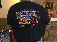 Back of jacket showing large colorful embroidery of National Baseball Hall of Fame Cooperstown logo with baseball player and stars.