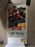 Poster photo showing the detailed fight scene and Budweiser branding. The poster is unframed and appears rolled out slightly on a carpeted floor.