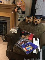 Photo showing foam hats with Hamilton Thunderbirds logo, inflatable doll, CFL printed materials arranged on chair and armrest.