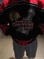 Front view showing Chicago Blackhawks logo, Stanley Cup image and 'Stanley Cup Champions 2010' text with black, red, and white design.
