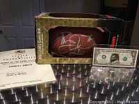 Signed football inside original Wilson NFL display box alongside COA and novelty note