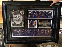 Full view of the framed memorabilia showing all included components under glass, with black frame.