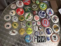 Top view photo showing 41 assorted NHL and hockey themed pin back buttons arranged on a flat surface, displaying various team logos and designs.