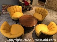 Overview of four yellow barrel swivel chairs arranged around round wooden table