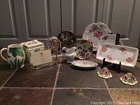 Full lot showing various porcelain and ceramic items including plates, creamer, and a pitcher with floral designs