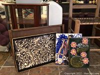 Photo of four decorative tea trays with various intricate designs and colors, arranged upright for display.