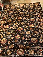 Full view of Turkish style floral rug showing the entire pattern and color scheme on black background.