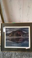 Frontal view of framed print leaning against wallpapered wall