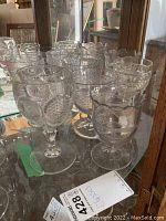 Group photo showing eight vintage glass goblets with various shapes and intricate pressed and embossed glass patterns.