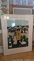 Framed limited edition print displayed leaning against a wall with floral wallpaper and an air conditioning unit behind it, photo shows the print image and frame clearly.