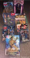 Seven new figurines in original packaging including GI Joe, The Beatles Yellow Submarine, Harry Potter, and Child's Play 2 figures shown together.