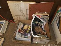 Two boxes filled with assorted vintage magazines and newspapers, morning newspapers and magazines with various covers visible