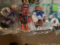 Four sealed NHL Muppets plush dolls laid side by side in clear plastic bags, showing full lengths and detailed uniforms with NHL logos.