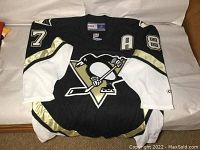Folded front view of black CCM Pittsburgh Penguins jersey with large penguin logo