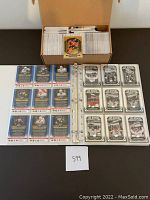 Open box with stacked 2020-2021 Tim Hortons hockey cards and binder pages showing front and back sides of cards inside a plastic sleeve.