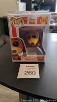 Front view of unopened Funko Pop Slinky Dog figure inside original box and clear pop protector case, with lot tag in front.