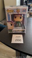 Front view of unopened Funko Pop! Toy Story 4 Buzz Lightyear #523 vinyl figure in original box and protective Pop Protector case, placed on a black table.