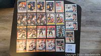 Top view of 24 NHL Mario Lemieux hockey cards arranged in rows on table, showing different card designs and player images.