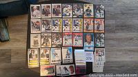 Full view of approximately 30 Wayne Gretzky NHL hockey cards laid out on floor, showing various card designs and players in hockey action or portraits.